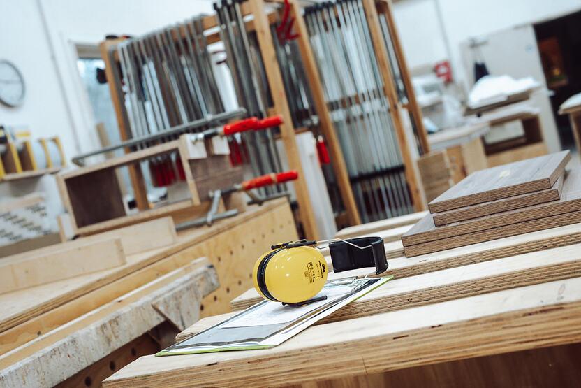 Bankraum Bankraum der Tischlerei Lohse aus Kisdorf. Im Vordergrund befindet sich ein Gehörschutz auf einem Tisch. Der Hintergrund bildet einen Wagen mit Schraubzwingen