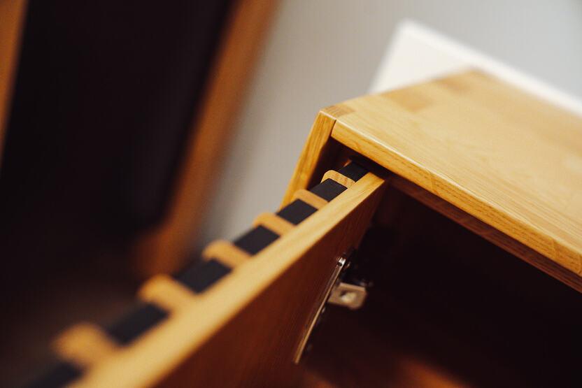 elegantes Eichenholz Möbelstück abgebildet ist ein Eichenholz Möbelstück mit schwarzen Akzenten und einer Zinkenverbindung zu dem ist auch ein Schnier zu erblicken