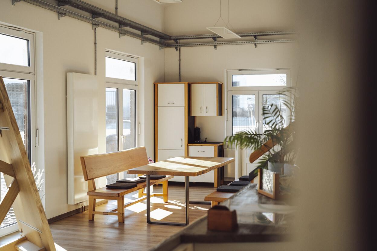 Besprechungstisch im IDEEN REICH Besprechungstisch aus massiver Eiche in einem lichtdurchfluteten IDEEN REICH mit weißer Wandfarbe