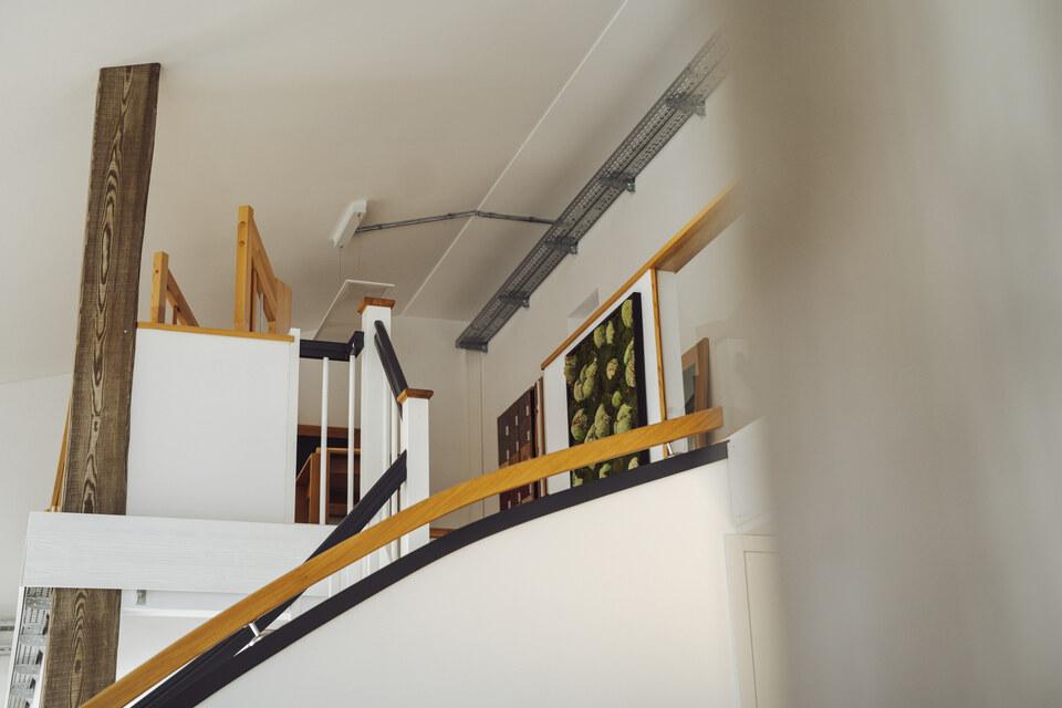 Treppenbereich Ansicht von unten nach oben auf den Treppenbereich des IDEEN REICHs in weiß und holzfarbend gehalten