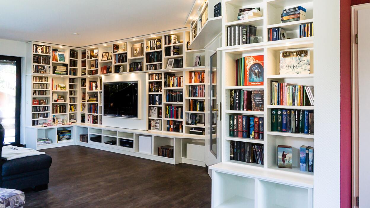 Impression Regalwand Eine große Mediaregalwand aus Holz mit Büchern und einem Fernseher