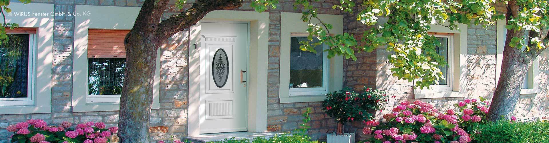 Weiße Haustür nach Maß Weiße Haustür individuell gestaltet in Hauswand vor Bäumen